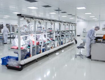 people in white isolating costumes working in laboratory